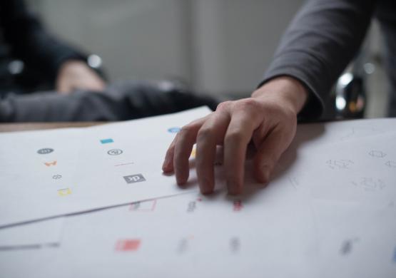 man touching piece of paper with different logos 